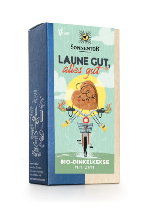 Schachtel SONNENTOR KEKS LAUNE GUT, ALLES GUT vegane Dinkelkekse mit Zimt, mit der Illustration eines lächelnden Kekses, der unter der Sonne Fahrrad fährt.