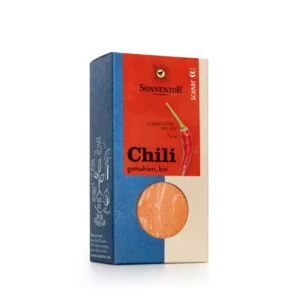 Schachtel SONNENTOR BIO CHILI GEMAHLEN in rot-blauer Verpackung, mit Chili-Illustration und Gewürz durch ein transparentes Fenster sichtbar.