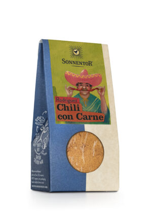 Eine Packung der Gewürzmischung SONNENTOR CHILI CON CARNE verfügt über ein Sichtfenster mit Blick auf den Inhalt sowie die Abbildung einer Person mit Sombrero.