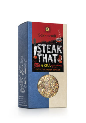 Eine Schachtel SONNENTOR STEAK THAT GEWÜRZMISCHUNG mit getrockneten Tomaten hat ein blau-beiges Design mit einem roten Etikett und Illustrationen.