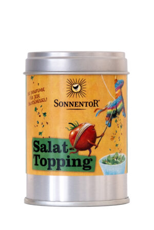 Metalldose mit der Aufschrift „SONNENTOR SALAT GEWÜRZ DOSE“ und gelbem Etikett mit Tomaten-Illustration und „Salat-Topping“, sowie kleiner Salatschüssel rechts unten.