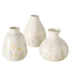 Drei Vasen DEKO BLOSSOM VASE STEINGUT aus weißer Keramik mit pastellfarbenen Blumenmustern und grünen Rändern sind vor einem schlichten Hintergrund gruppiert.