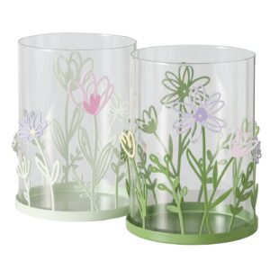 Das DEKO WINDLICHT BLOSSOM Set besteht aus zwei klaren zylindrischen Behältern mit pastellgrünen und violetten Blumenmustern, grünen Böden und ausgeschnittenen Blumen und Blattmustern um die Böden.