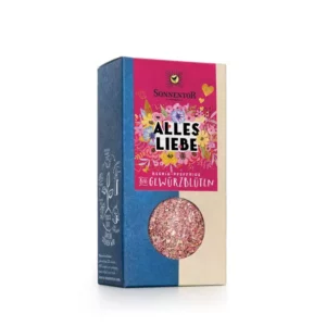 Schachtel SONNENTOR GEWÜRZBLÜTEN ALLES LIEBE Gewürzmischung mit floralem Design, rosa-blauer Verpackung und transparentem Fenster zur Anzeige des Inhalts.