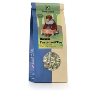 Eine Packung SONNENTOR BASEN FASTENZEIT TEE LOSE Kräutertee zeigt ein Motiv mit einem Bären im Kleid und Schürze, der an einem Tisch sitzt.
