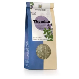Eine Tüte SONNENTOR THYMIAN LOSE trägt auf der Vorderseite das Markenlogo und eine violette Kräuterillustration, die Verpackung ist überwiegend in Blau und Beige gehalten.