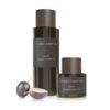 Zwei Flaschen VINO PURE GRAPE SEED OIL von Vinoble Cosmetics mit einer halbierten Weintraube daneben.