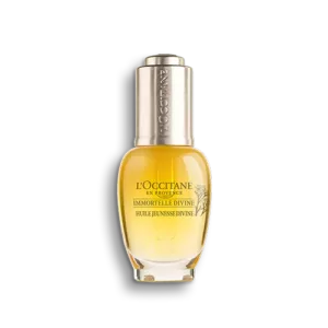 Eine Flasche IMMORTLLE DIVINE YOUTH OIL mit silberner Kappe und gefüllt mit gelber Flüssigkeit.