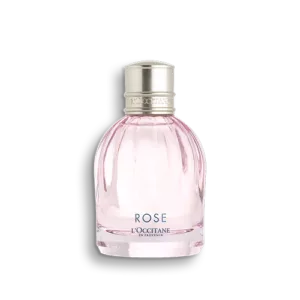 Ein klares rosa Parfümfläschchen mit silberner Kappe und der Aufschrift „ROSE EAU DE TOILETTE“ von LOccitane.
