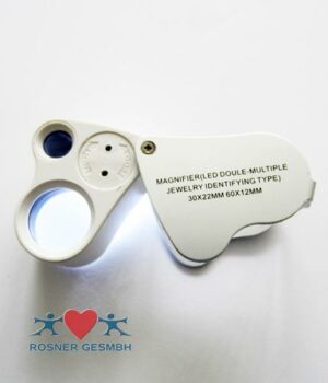 Schmucklupe mit Beleuchtung und Textanzeige: „LUPE LED ETUI 30X +60X“. Logo mit zwei blauen Figuren und einem roten Herz.