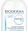 Auf einer 250 ml großen, durchsichtigen Plastikflasche mit Mizellenwasser BIODERMA HYDRA H2O REINLSG und blauem Deckel steht ein Text auf Französisch und Englisch, der das Wasser als feuchtigkeitsspendende Lösung zum Abschminken beschreibt.