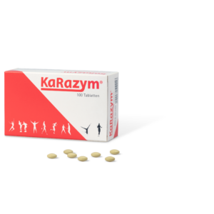 Eine Schachtel KARAZYM TBL mit abgebildeten Sportfiguren, daneben mehrere verstreute gelbe Tabletten.