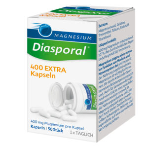 Geöffnete Schachtel MAGN DIASP.400 EXTR KPS, aus deren Behälter weiße Kapseln herausquellen und auf der Verpackung ist ein deutscher Text deutlich zu erkennen.