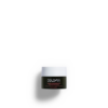 Ein kleines Gefäß mit DOLOMIA REMEDY REGENERIERENDE CREME, bestehend aus einem dunklen Gefäß mit weißem Deckel und Text, präsentiert vor einem schlichten Hintergrund.